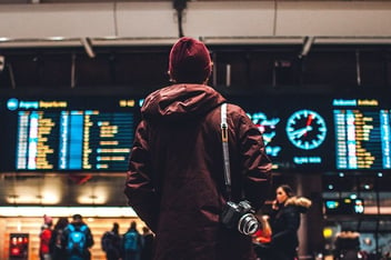 Eine Person steht vor der Anzeigetafel am Flughafen