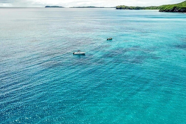 Boote auf dem Wasser vor einer der Fidschi-Inseln